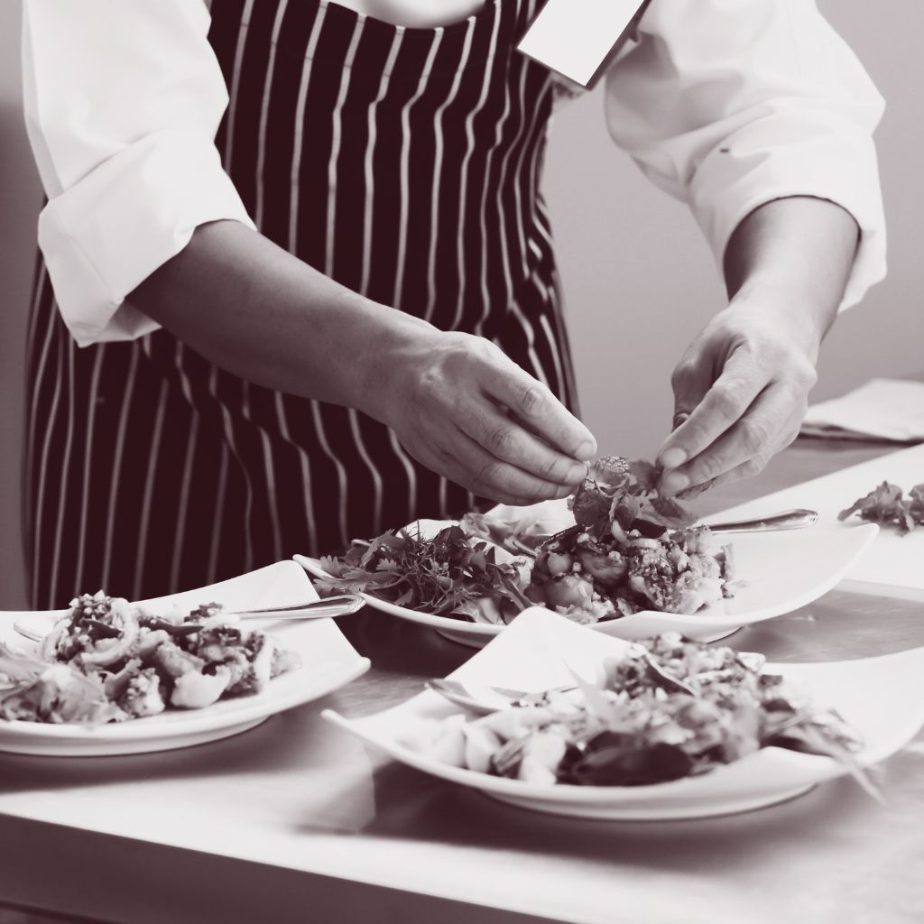 Chef voegt de finishing touch toe aan een gerecht bereid met convenience producten in de keuken.